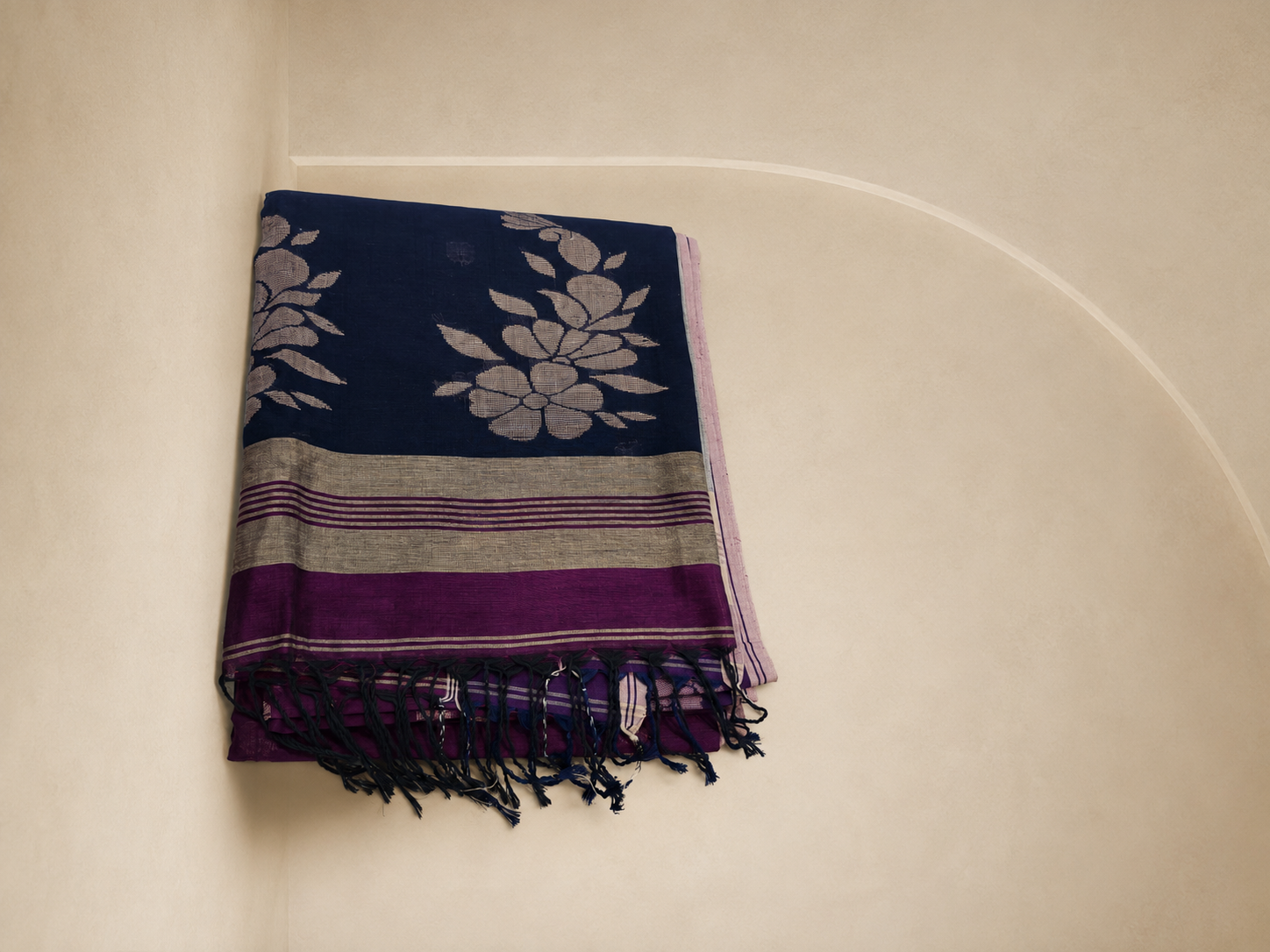 Folded Mayurika Bengal cotton saree with navy floral pallu and tassels