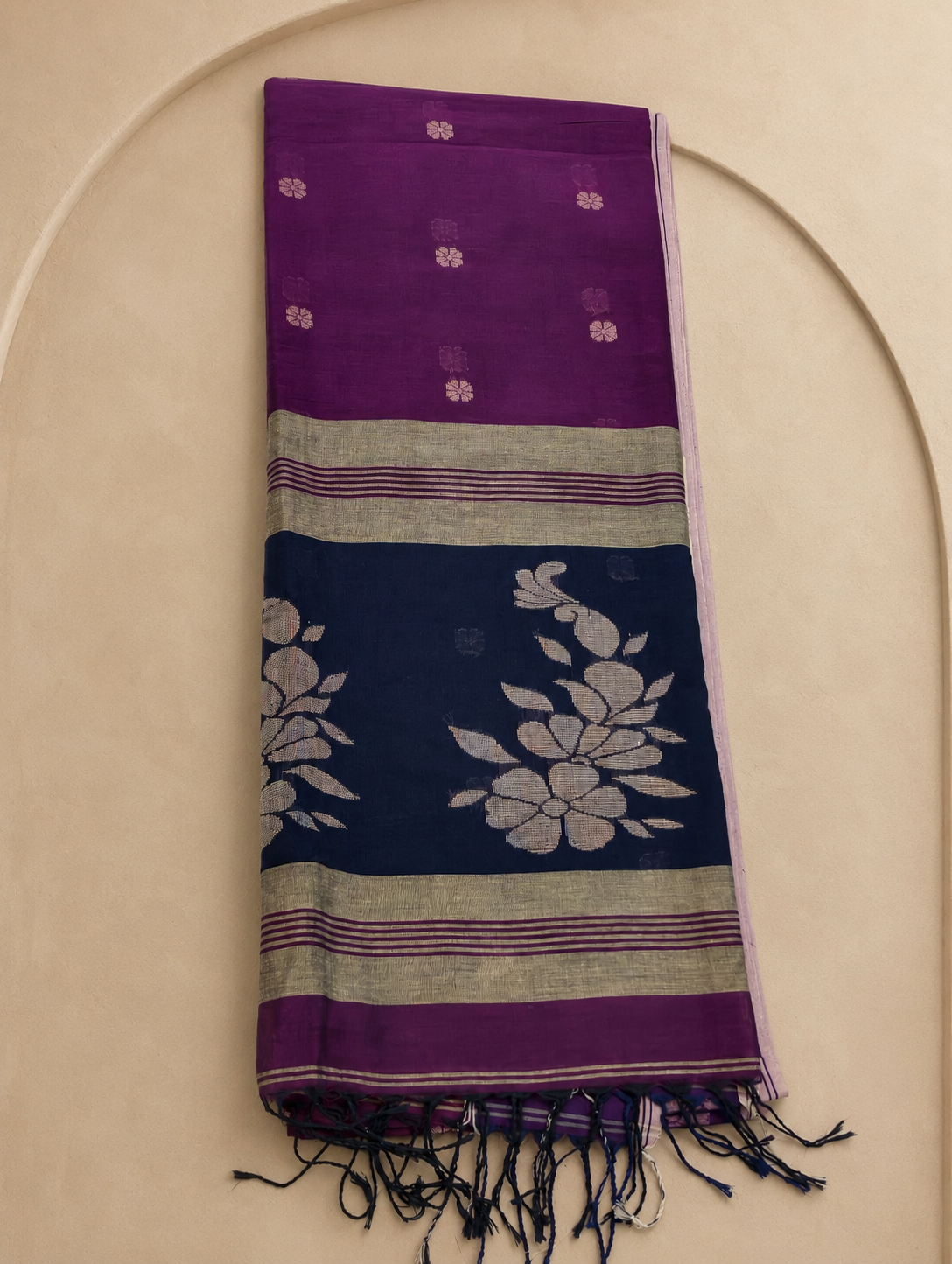 Folded Mayurika magenta Bengal cotton saree showing navy floral pallu