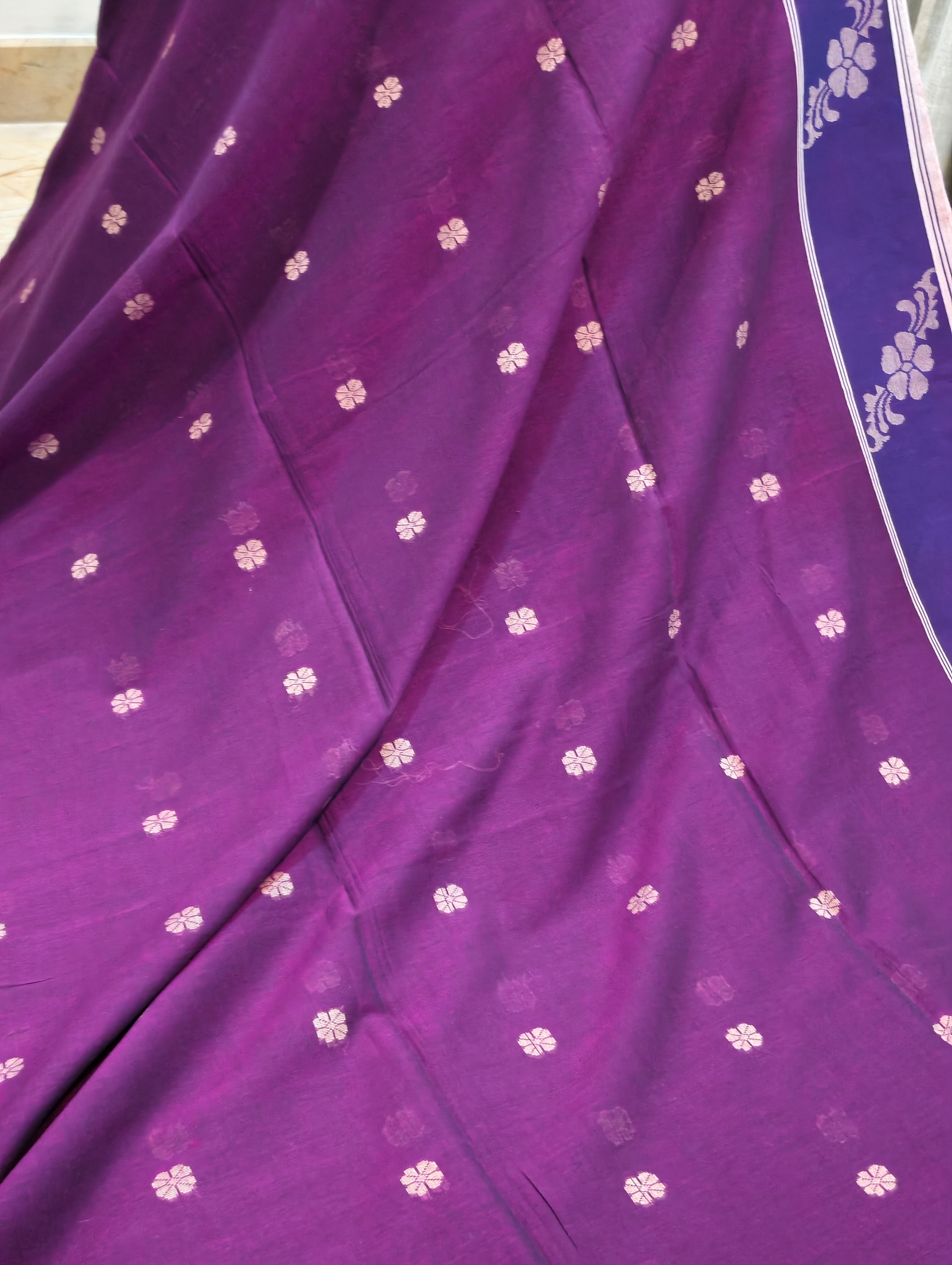 Close-up of woven motifs and floral border on magenta Bengal cotton saree