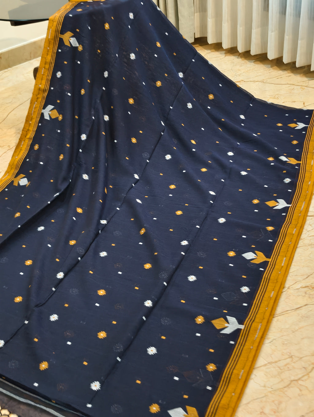 Close-up of navy blue Bengal cotton saree with small mustard and white woven motifs