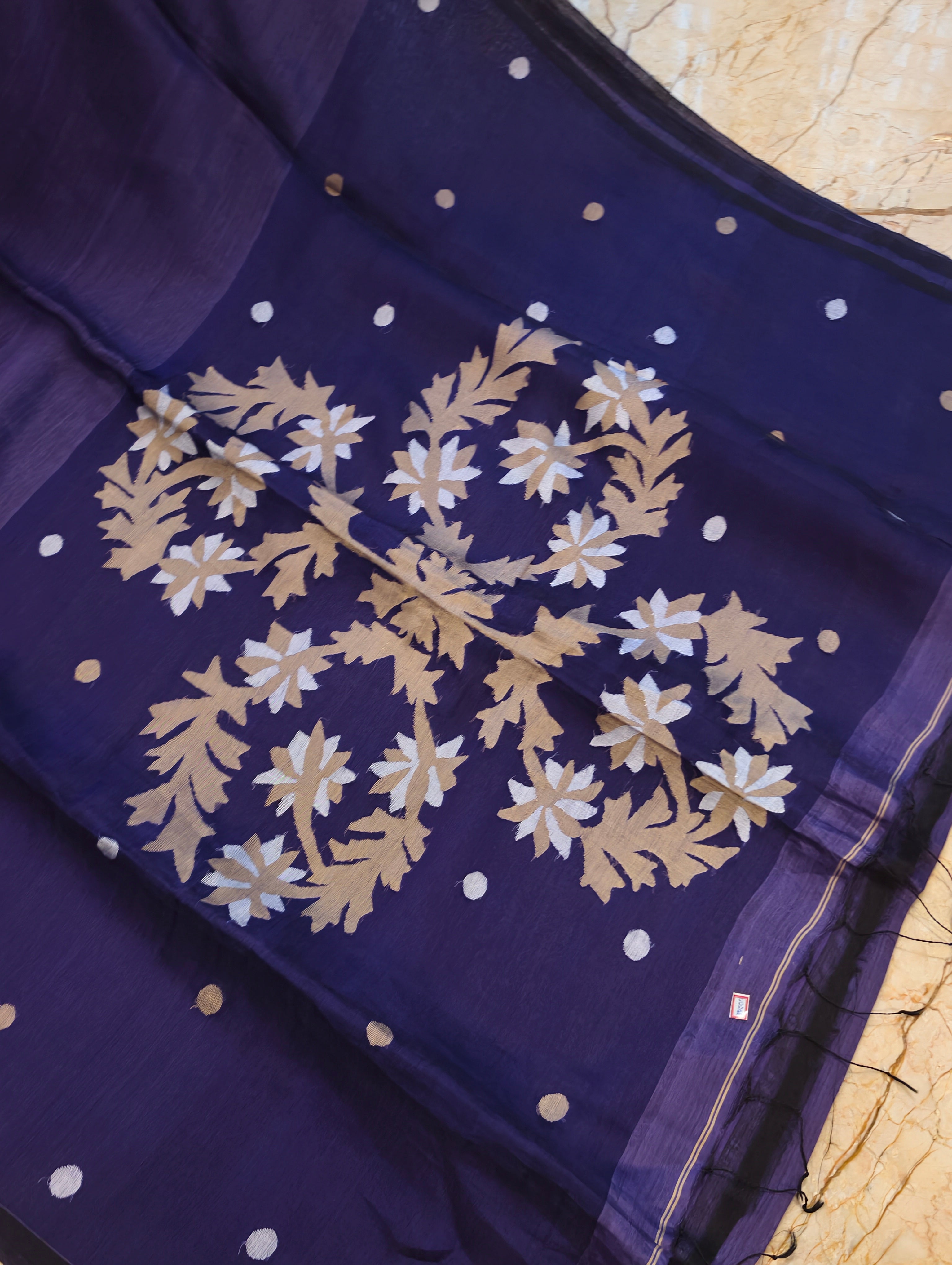 Detailed view of gold and white handwoven Jamdani floral motifs on purple Matka Muslin saree