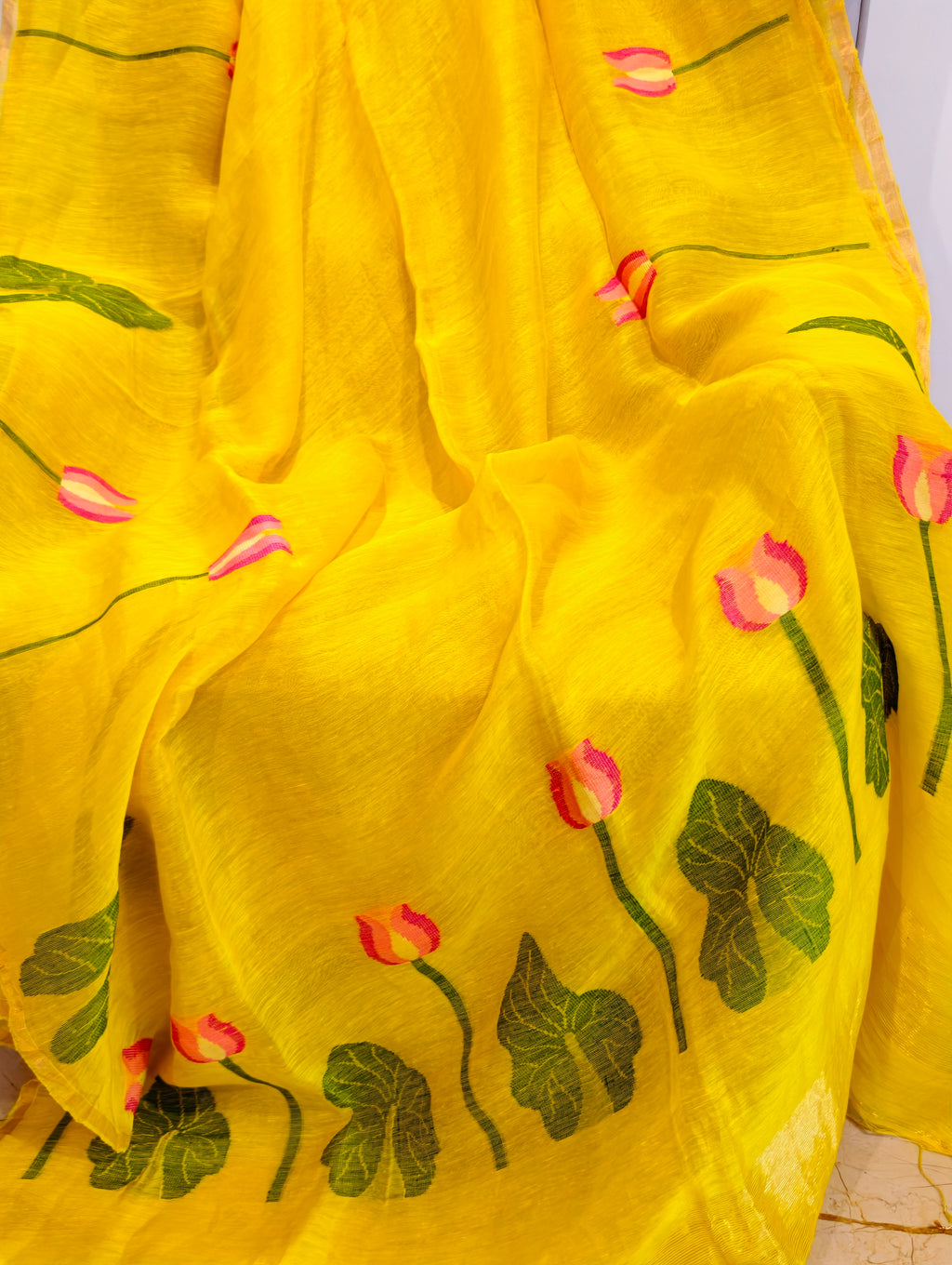 Close-up of yellow Matka silk Jamdani saree with woven pink lotus flowers and green leaves – Nayikaa