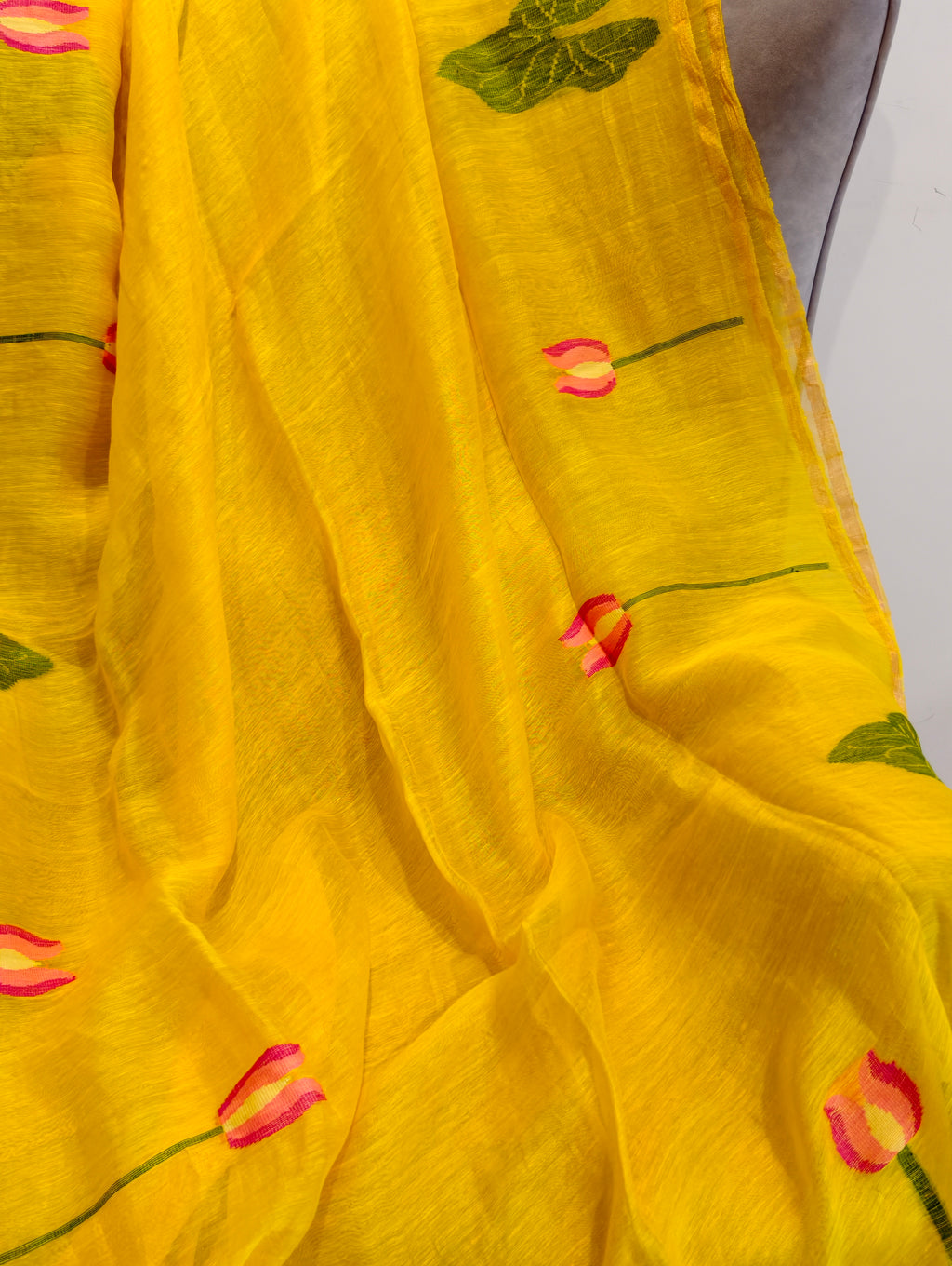 Close-up of yellow Matka silk Jamdani saree with woven pink lotus and green leaf motifs – Nayikaa