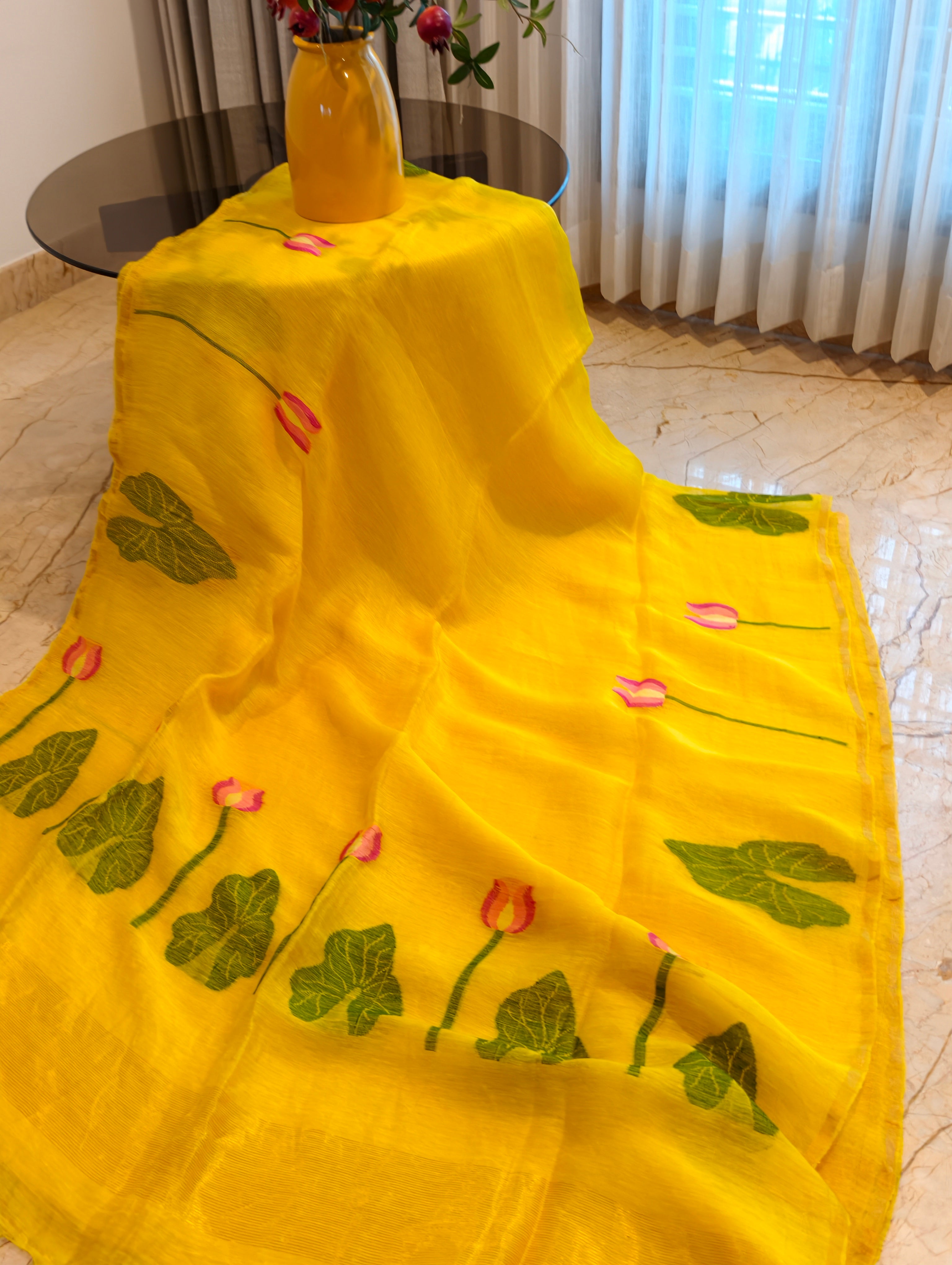 Close-up of yellow Matka silk Jamdani saree with woven pink lotus flowers and green leaves – Nayikaa